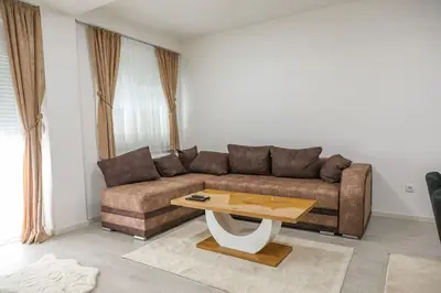a living room with a brown couch and a coffee table at Apartman Jelena in Vranje