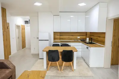 a kitchen with a wooden table and chairs at Apartman Jelena in Vranje
