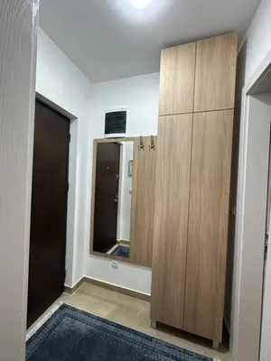 a bathroom with a wooden cabinet and a mirror at Talija apartman 4 in Vrnjačka Banja