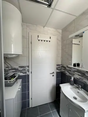 a bathroom with a white door and a sink at Talija apartman 4 in Vrnjačka Banja