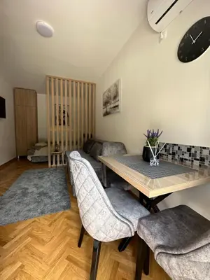 a living room with a wooden table and chairs at Talija apartman 4 in Vrnjačka Banja