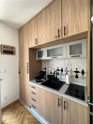 a kitchen with wooden cabinets and a sink at Talija apartman 4 in Vrnjačka Banja