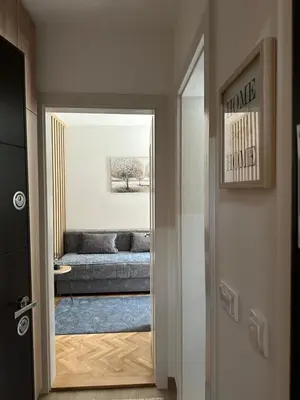 a hallway with a doorway to a room with a couch at Talija apartman 4 in Vrnjačka Banja