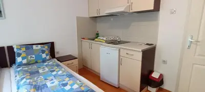 a small room with a bed and a small kitchen at Maja V Apartmani Sokobanja in Soko Banja