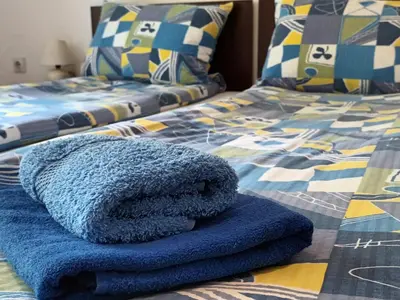 a bed with blue towels sitting on top of it at Maja V Apartmani Sokobanja in Soko Banja