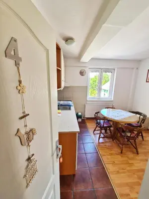 a kitchen and dining room with a table and a door at Maja V Apartmani Sokobanja in Soko Banja