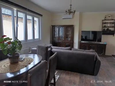 a living room with a couch and a table at Garfield Family Apartman 1 in Soko Banja