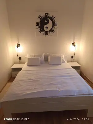 a bedroom with a large white bed with two lamps at Garfield Family Apartman 1 in Soko Banja