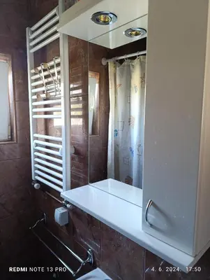 a bathroom with a white sink and a mirror at Garfield Family Apartman 1 in Soko Banja