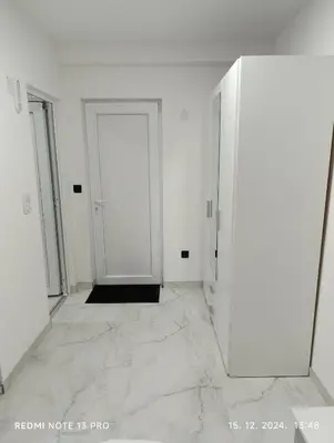 an empty room with a door and a tile floor at Garfield Family Apartman 1 in Soko Banja
