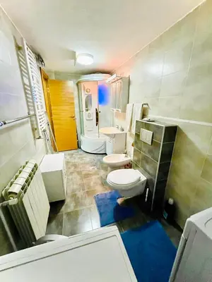 a bathroom with two toilets and a sink and a tub at Apartman Family in Vrnjačka Banja