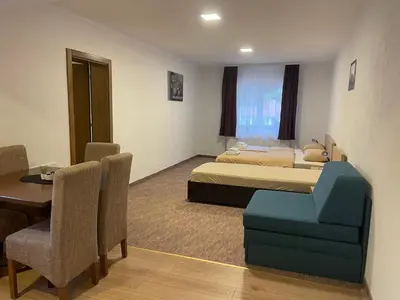 a hotel room with two beds and a table and chairs at 4 vodenice Brzeće B&B in Brzeće