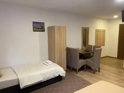 a hotel room with a bed and a table and chairs at 4 vodenice Brzeće B&B in Brzeće