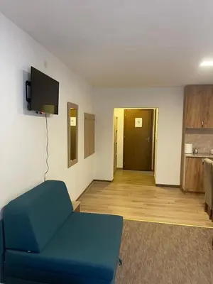a living room with a blue couch and a television at 4 vodenice Brzeće B&B in Brzeće