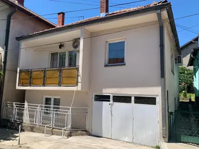 a white house with a gate and a garage at Kuca u Prokuplju in Prokuplje