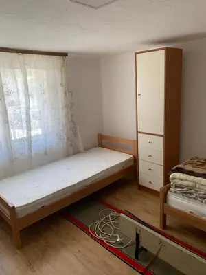 a small bedroom with a bed and a cabinet at Kuca u Prokuplju in Prokuplje