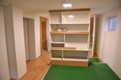 a room with white shelves and a green rug at Kuca u Prokuplju in Prokuplje