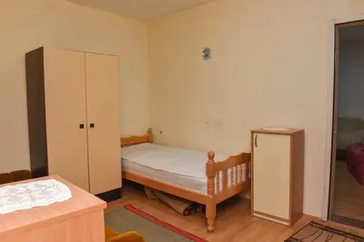 a small bedroom with a bed and a cabinet at Kuca u Prokuplju in Prokuplje