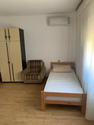 a small bedroom with a bed and a chair at Kuca u Prokuplju in Prokuplje