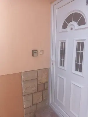 a white door in a room with a brick wall at Apartman Bagdala in Kruševac