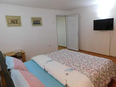 a bedroom with a bed and a flat screen tv at Apartman Bagdala in Kruševac