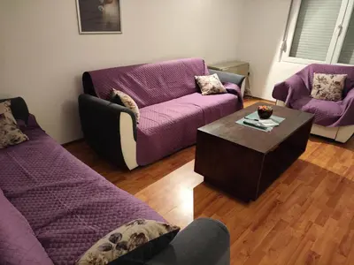 a living room with purple couches and a coffee table at Apartman Bagdala in Kruševac