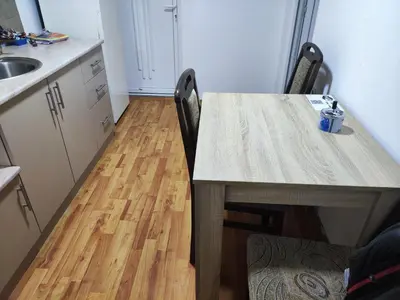 a kitchen with a table with two chairs and a sink at Apartman Bagdala in Kruševac