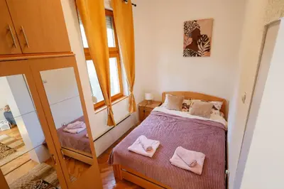 a small bedroom with a bed and a mirror at Ilić Sokobanja in Soko Banja