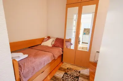 a small bedroom with a bed and a mirror at Ilić Sokobanja in Soko Banja