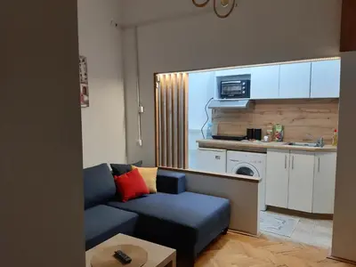 a living room with a blue couch and a kitchen at Ilić Sokobanja in Soko Banja