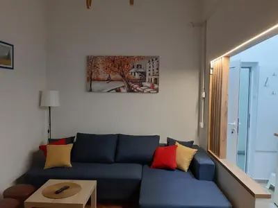 a living room with a blue couch with colorful pillows at Ilić Sokobanja in Soko Banja