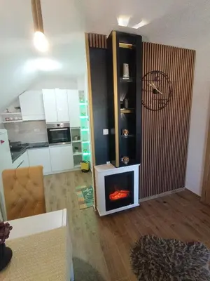 a living room with a fireplace in a living room at Apartman Tina , kod hotela Sunce in Soko Banja