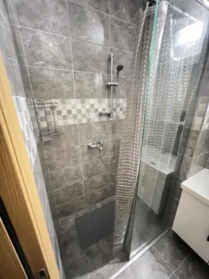 a shower with a glass door in a bathroom at Apartman Tina , kod hotela Sunce in Soko Banja