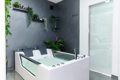 a bathroom with a tub with plants on the wall at SPA apartman Tomin adults only in Soko Banja