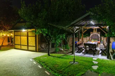 a backyard with a table and a gazebo at night at SPA apartman Tomin adults only in Soko Banja