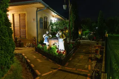 a house with two statues of people on the fence at SPA apartman Tomin adults only in Soko Banja