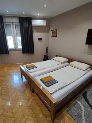 two twin beds in a room with two windows at 