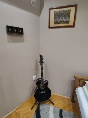 a guitar is sitting on the corner of a room at 