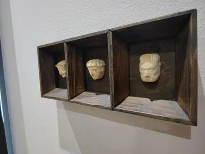 a shelf with three heads on a wall at 