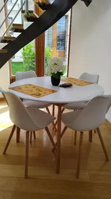 a dining room table with white chairs and a vase of flowers at Royal Villa - HAWAII in Vrnjačka Banja