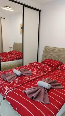 a bedroom with two beds with red sheets and towels at Royal Villa - HAWAII in Vrnjačka Banja