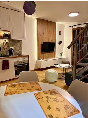 a kitchen and living room with a table and chairs at Royal Villa - HAWAII in Vrnjačka Banja