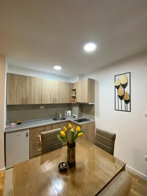 a kitchen with a wooden table with a vase of flowers on it at Rtanj in Soko Banja