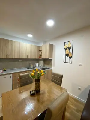 a kitchen with a wooden table with a vase of flowers on it at Rtanj in Soko Banja
