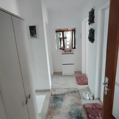 a hallway with white walls and a mirror and a door at Sokobanja na dlanu in Soko Banja