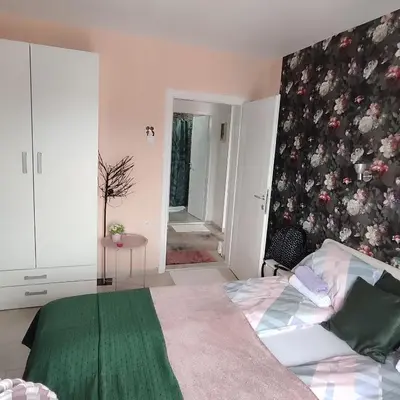 a bedroom with a bed with a green blanket at Sokobanja na dlanu in Soko Banja