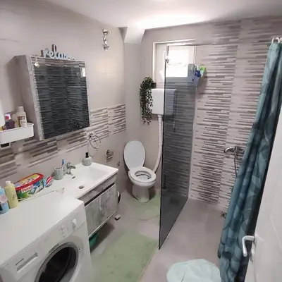a bathroom with a toilet and a sink and a washing machine at Sokobanja na dlanu in Soko Banja