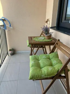 a table with a green pillow on a balcony at ADA Vrnjacka Banja in Vrnjačka Banja