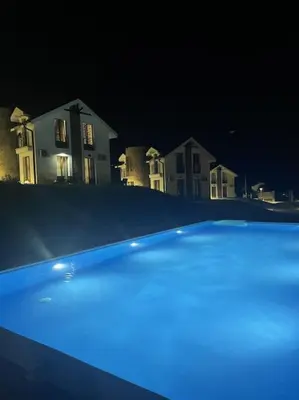 a blue car parked in front of a house at night at Royal King Villa 2 in Vrnjačka Banja