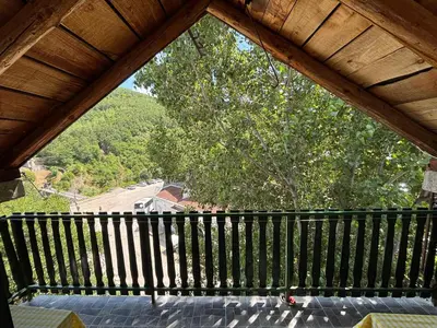 a large wooden balcony with a view of a tree at Lola in Prolomska Banja